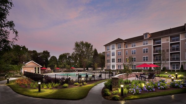 Resort-style pool at Marquee at Andover Apartments with shaded lounge areas and poolside seating