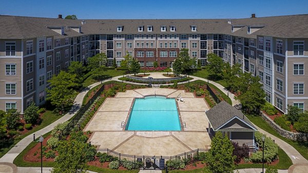 Outdoor swimming pool with lounge chairs and modern apartment building in the background