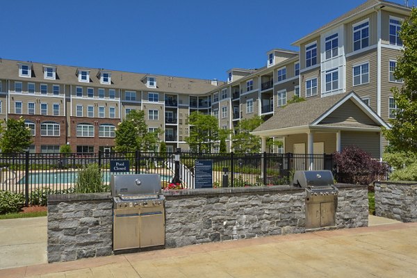 Outdoor grill area with modern seating at Marquee at Andover Apartments