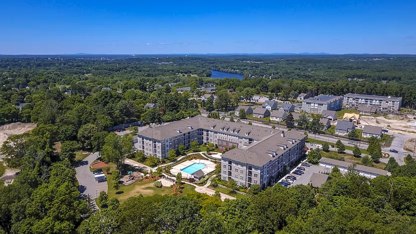 Luxury apartments with a swimming pool surrounded by greenery in a vibrant community