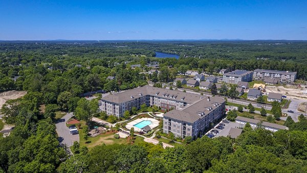 Luxury apartments with a swimming pool surrounded by greenery in a vibrant community