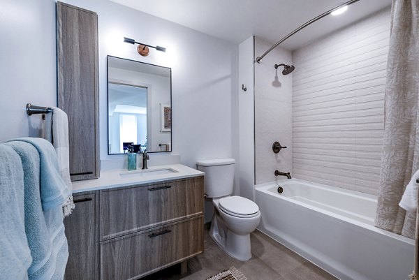 Illume Apartments: Modern bathroom featuring sleek fixtures and marble countertops in luxury apartment