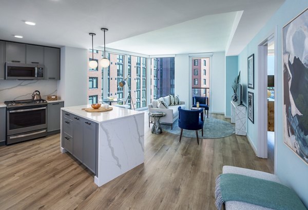 Modern kitchen with stainless steel appliances in Illume Apartments, featuring sleek countertops and designer cabinetry