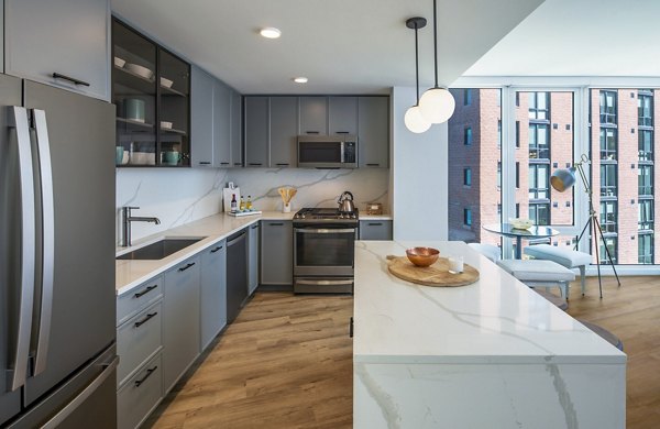 Modern kitchen with sleek countertops and stainless steel appliances at Illume Apartments