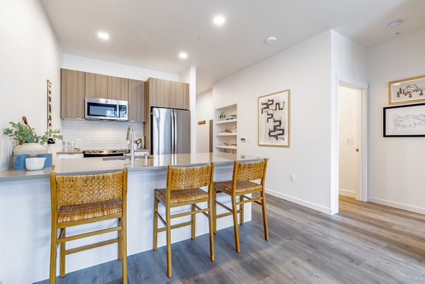 Modern kitchen with stainless steel appliances at Verde Esterra Park Apartments