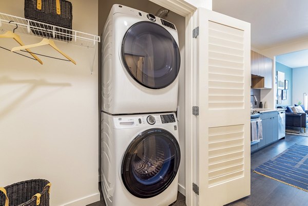 Laundry room featuring modern appliances at Verde Esterra Park Apartments