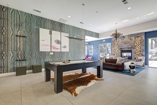 Game room with billiards table and lounge seating at Prosper Place Apartments