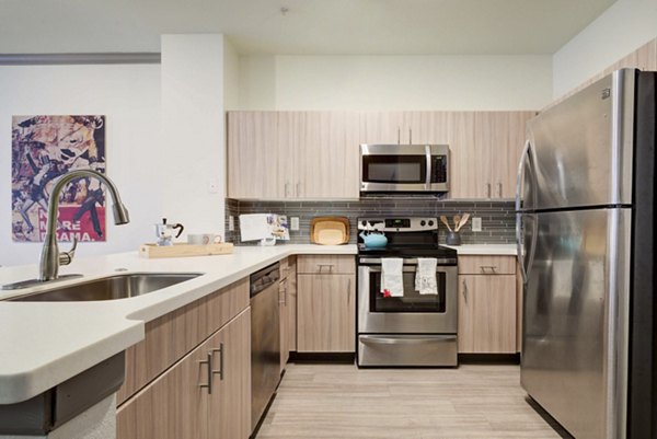 Modern kitchen with stainless steel appliances at Prosper Place Apartments