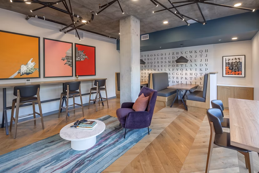 The Dylan Apartments: Chic clubhouse with modern decor and seating areas in urban apartment community