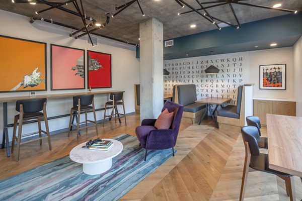 The Dylan Apartments: Chic clubhouse with modern decor and seating areas in urban apartment community