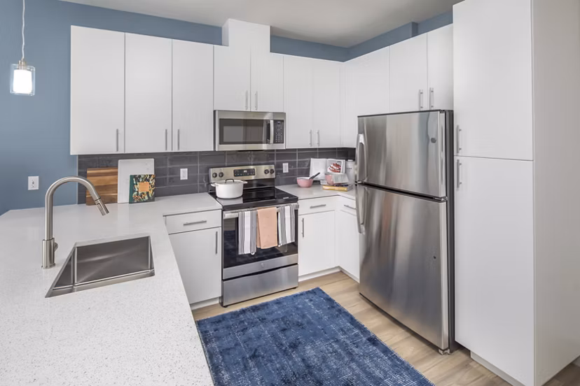 Modern kitchen featuring stainless steel appliances and granite countertops at The Dylan Apartments