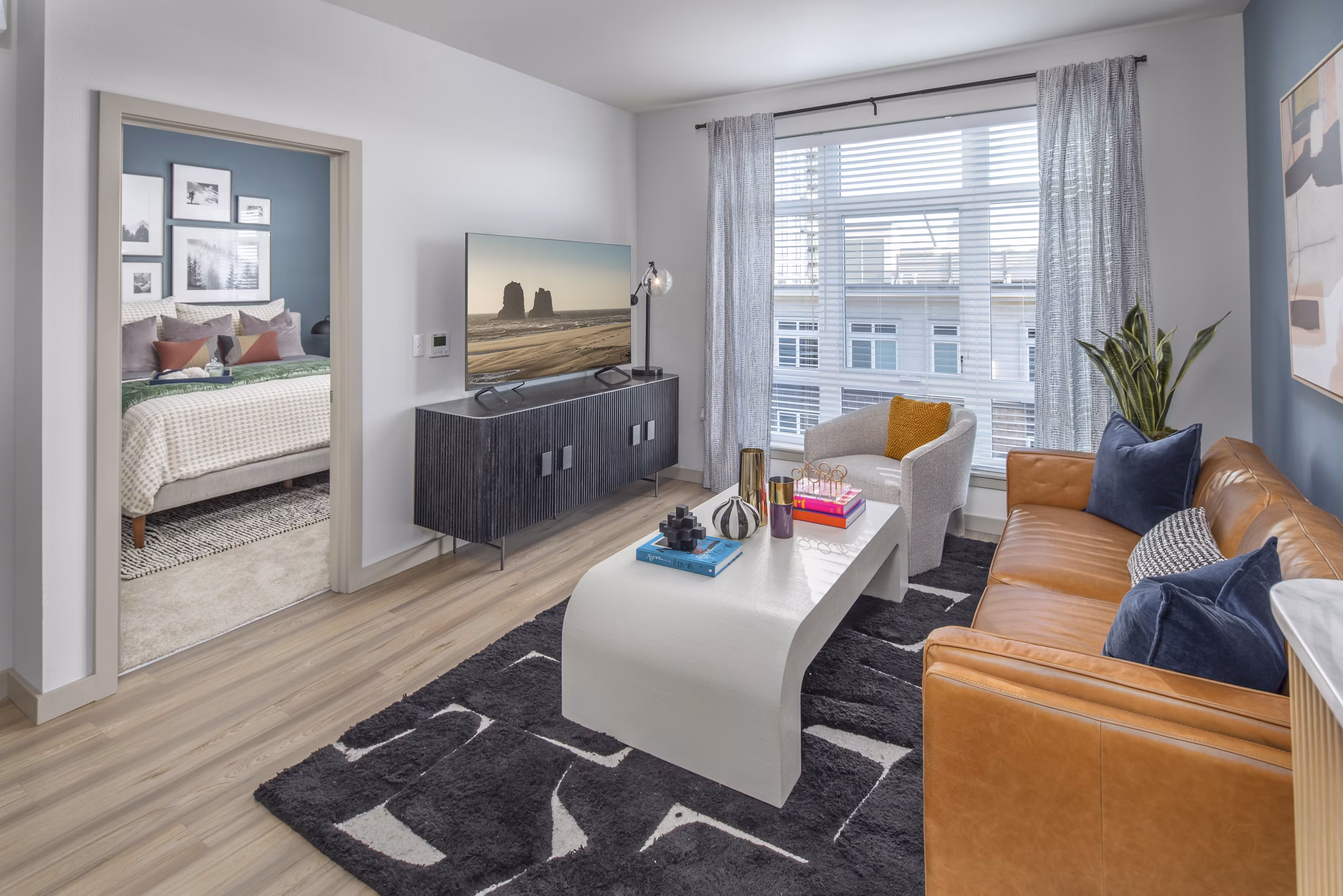 Spacious living room with modern furnishings and large windows in The Dylan Apartments, a luxury community