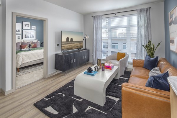 Spacious living room with modern furnishings and large windows in The Dylan Apartments, a luxury community
