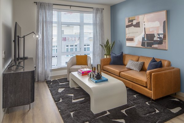 Spacious living room with modern decor and natural light at The Dylan Apartments