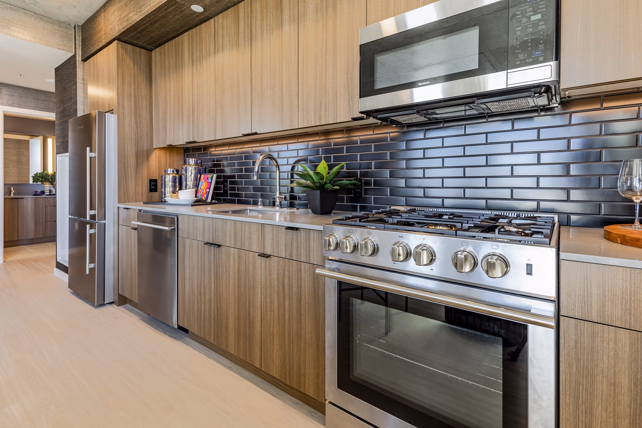 Modern kitchen with stainless steel appliances in The Waverly Apartments, offering luxurious living spaces in a vibrant community