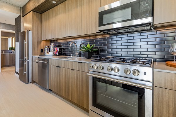 Modern kitchen with stainless steel appliances in The Waverly Apartments, offering luxurious living spaces in a vibrant community