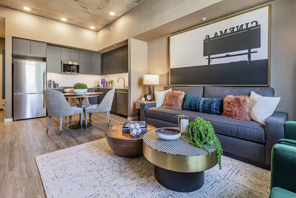Modern living room with sleek furniture and large windows at The Waverly Apartments