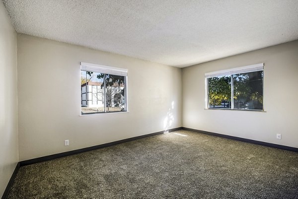 Modern bedroom featuring elegant furnishings and large windows at Calero Apartments, luxury living in a Greystar-managed community