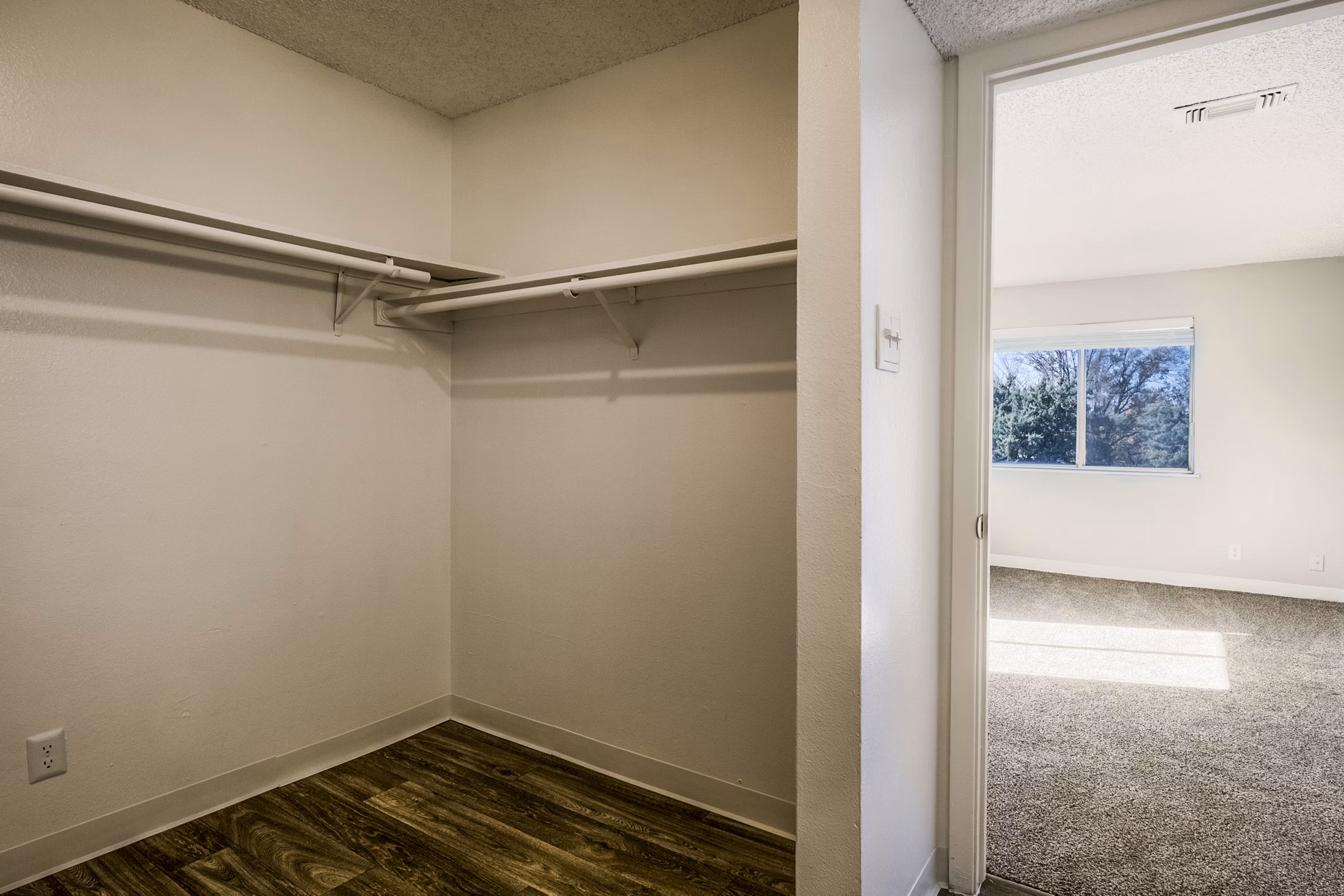 Calero Apartments: Spacious bedroom with modern furnishings and large windows in a luxury setting