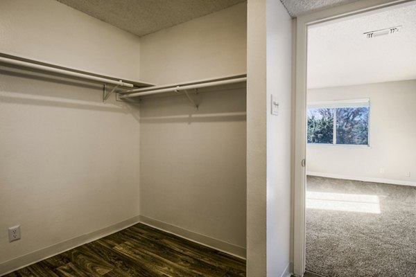 Calero Apartments: Spacious bedroom with modern furnishings and large windows in a luxury setting