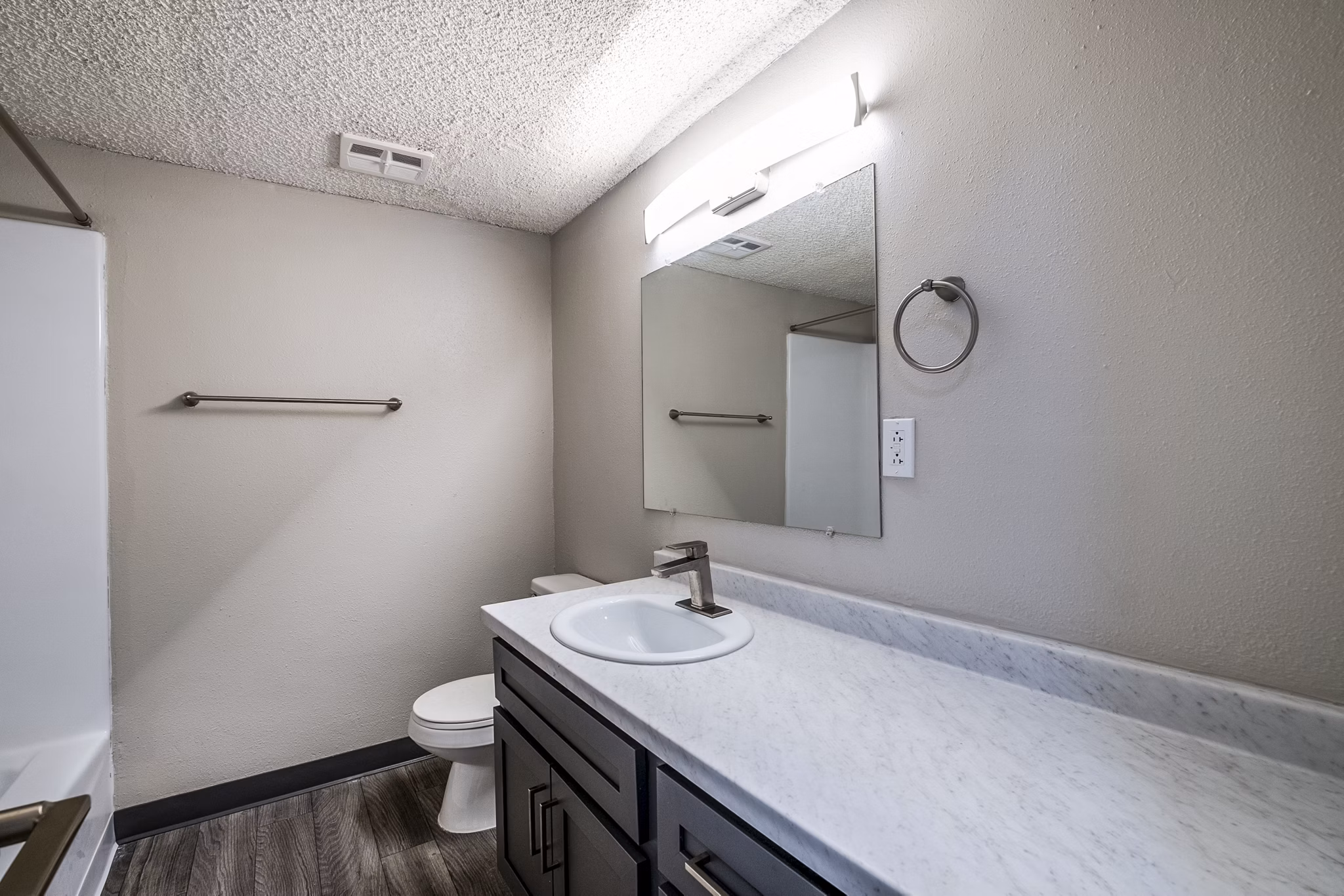 Luxurious bathroom with marble vanity and glass enclosed shower at Calero Apartments