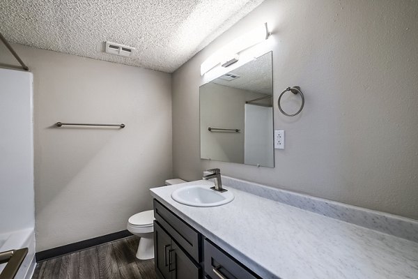 Luxurious bathroom with marble vanity and glass enclosed shower at Calero Apartments