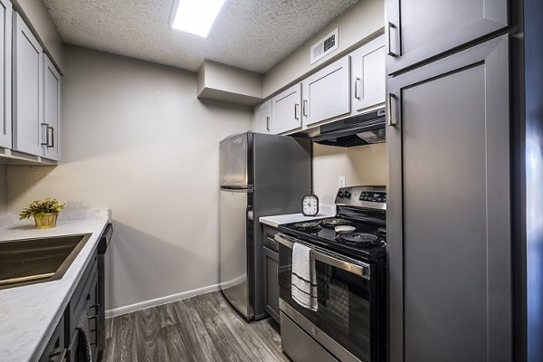 Modern kitchen featuring stainless steel appliances and granite countertops in Calero Apartments