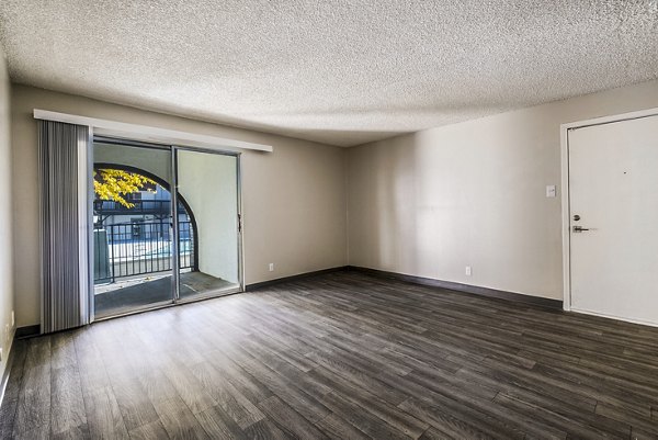 Living room with modern decor and large windows in Calero Apartments