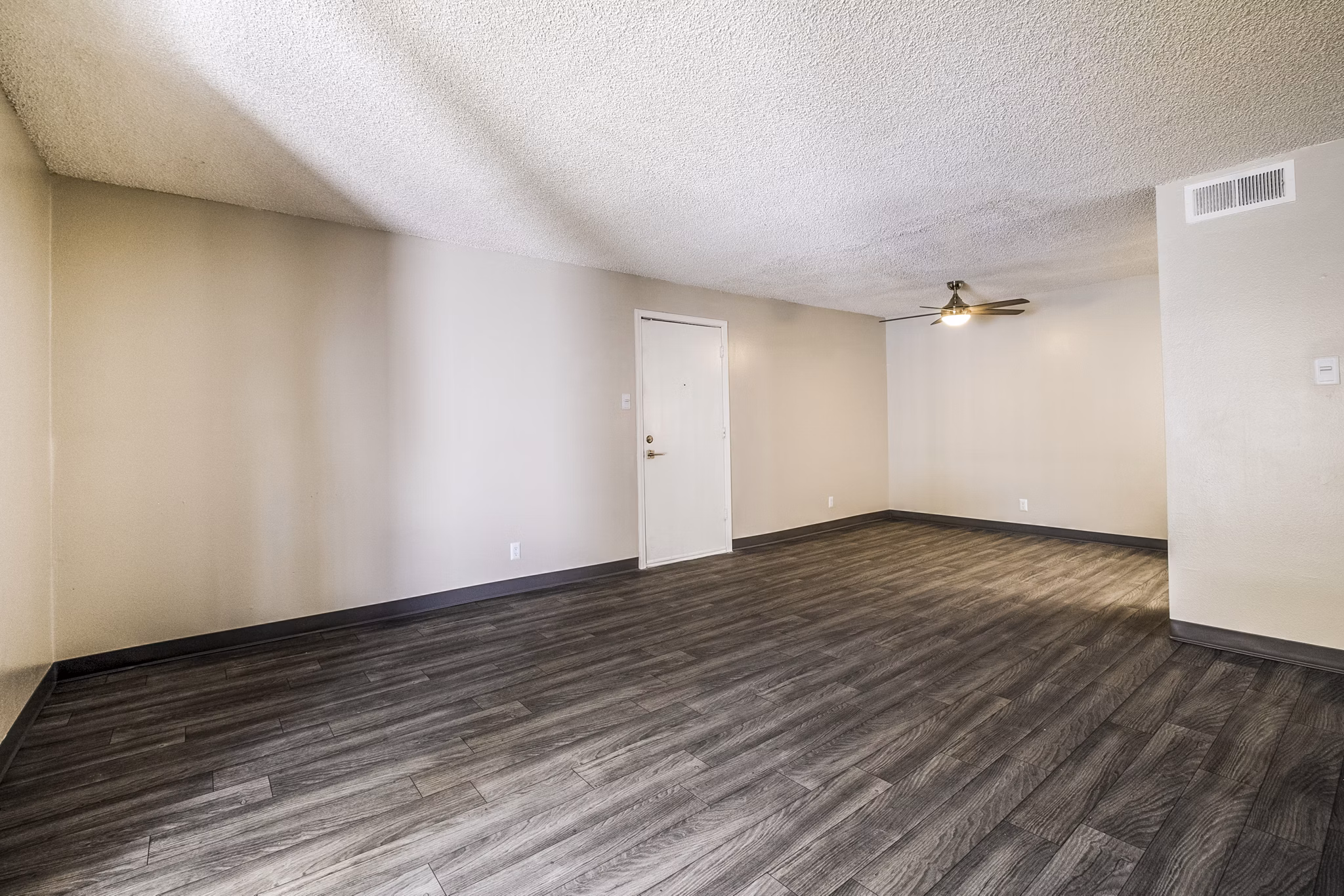 Spacious living room with modern decor at Calero Apartments, featuring luxury design elements and ample natural light