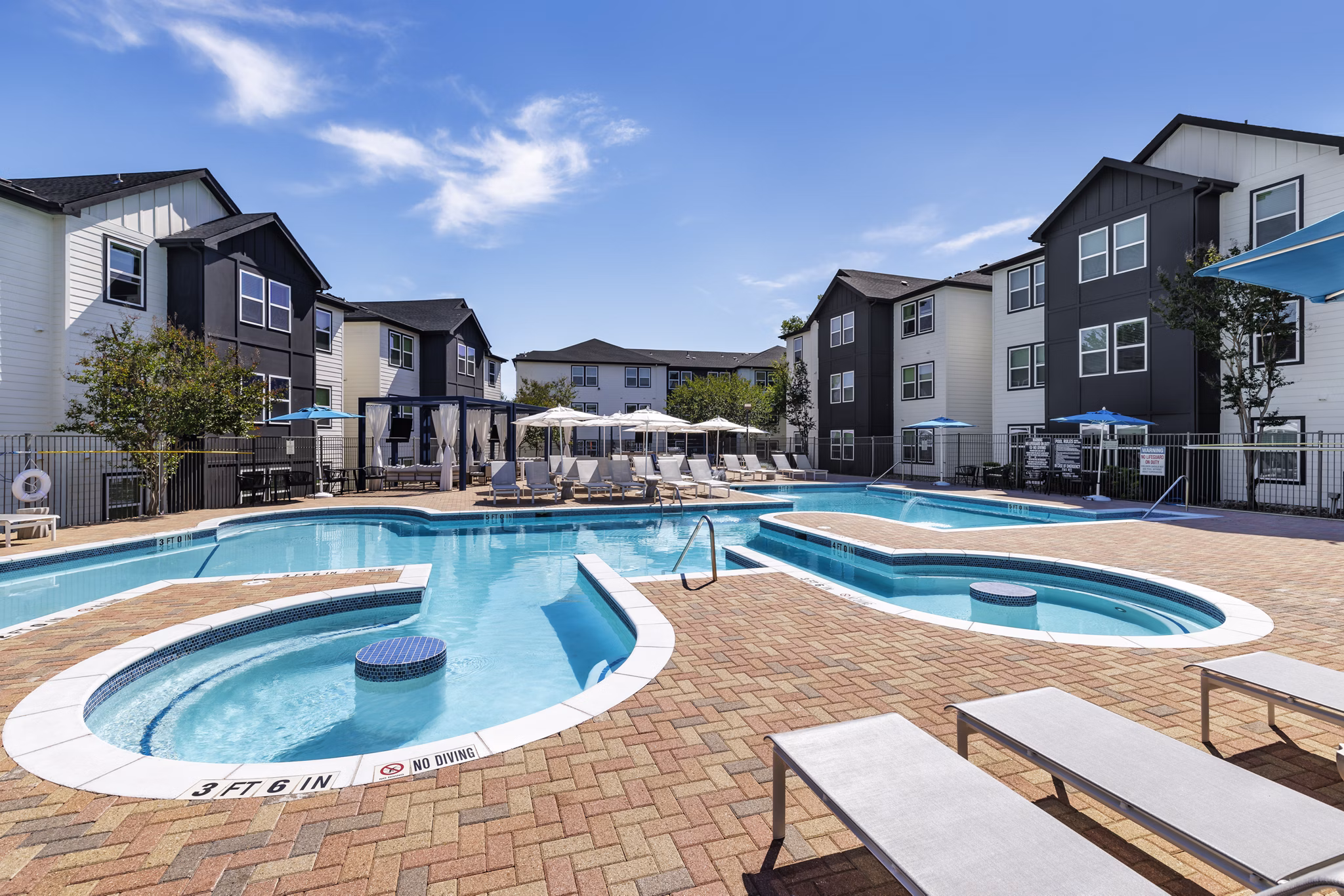Luxury pool with lounge chairs at Oltera in Southeast Apartments offering a relaxing oasis for residents