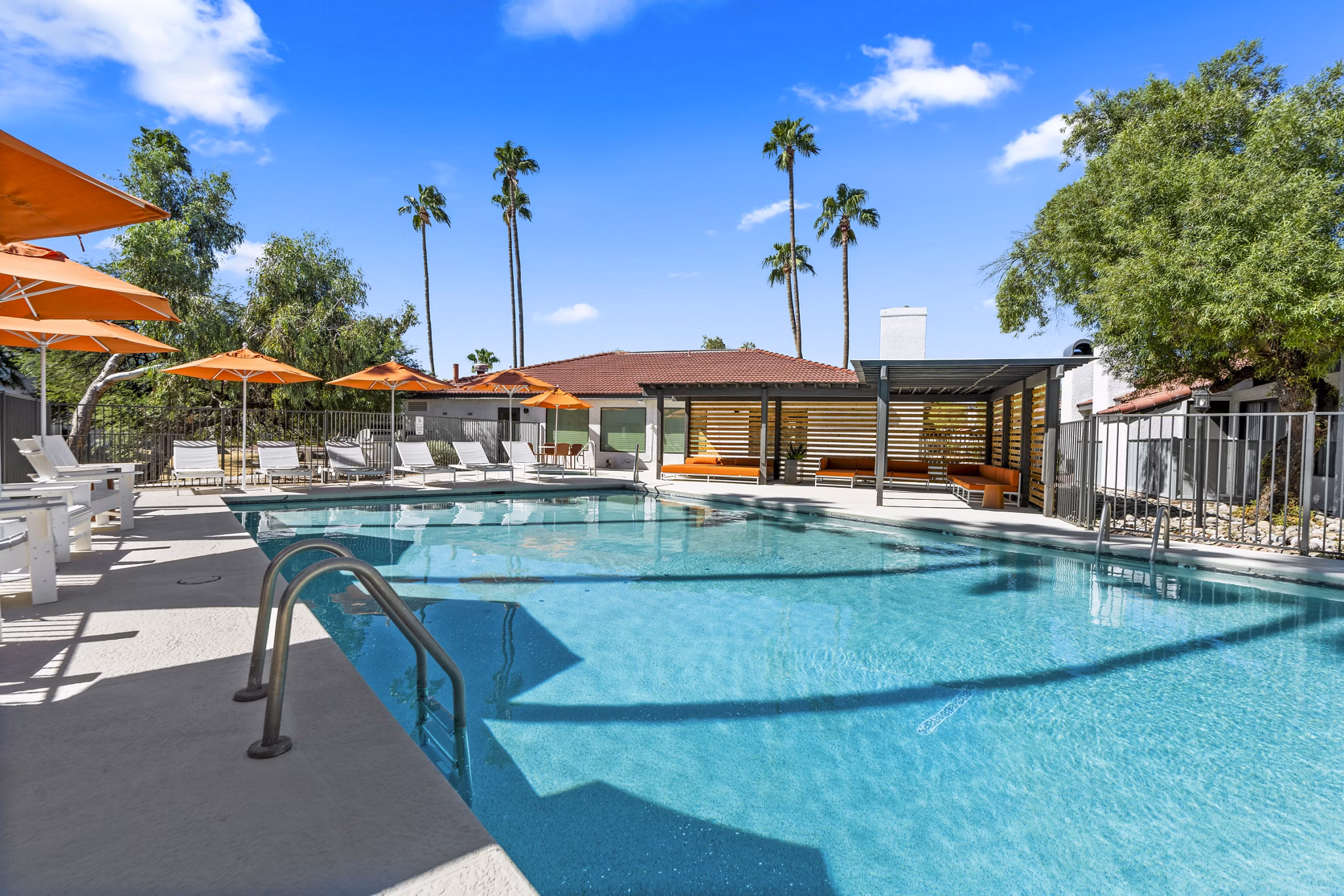 Relaxing outdoor pool area at Sparro Apartments, perfect for lounging and swimming in a vibrant community setting