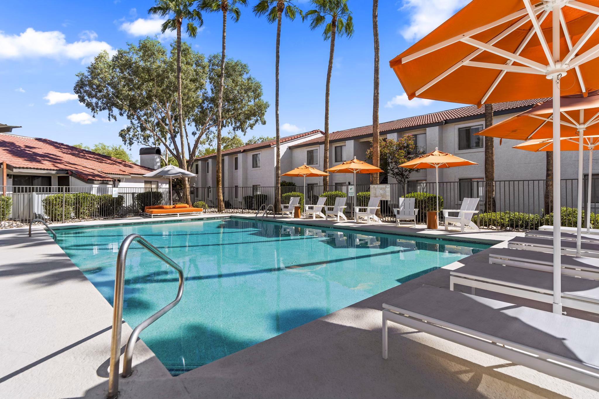 Sparkling outdoor pool at Sparro Apartments with sun loungers and landscaped surroundings, perfect for relaxation and leisure