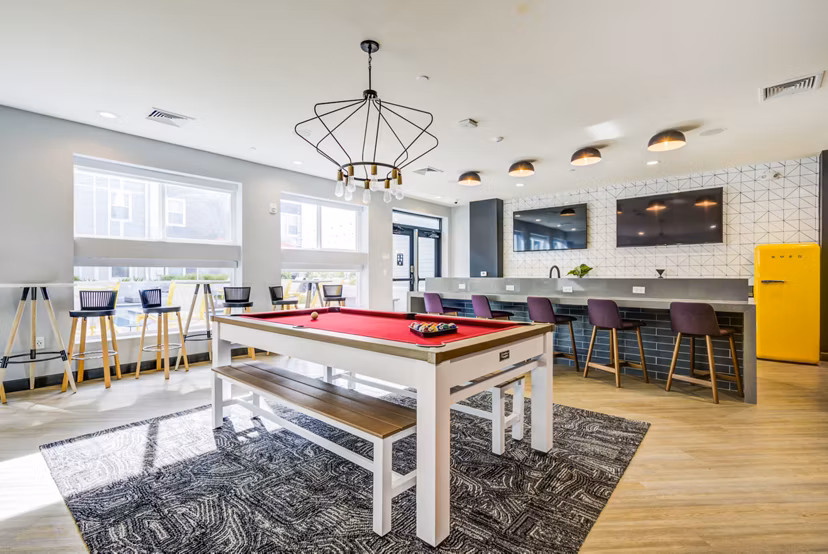 Modern game room with pool table and lounge seating at Union Tuscaloosa Apartments offering a luxury experience