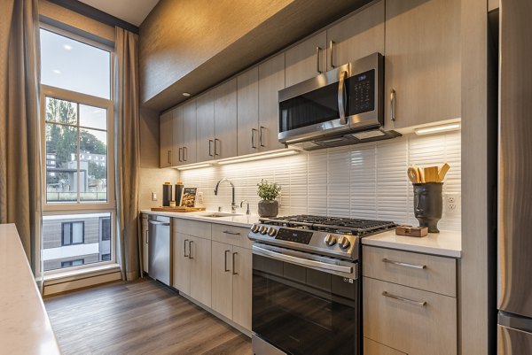 Kitchen featuring stainless steel appliances and a spacious island in Arista Apartments luxury community