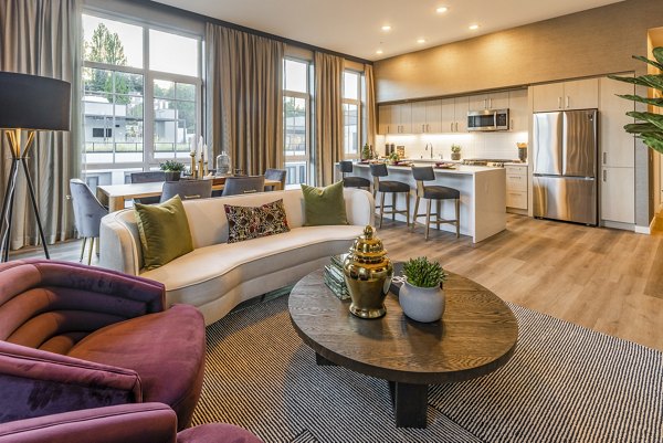 Living room featuring contemporary decor with large windows in Arista Apartments