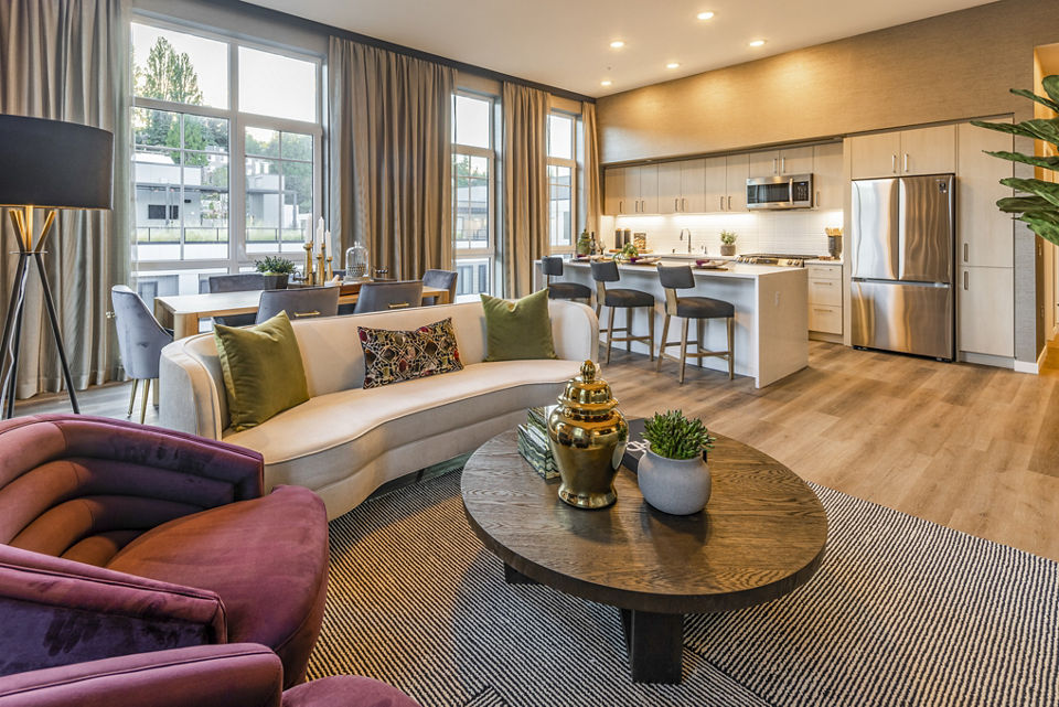 Living room featuring contemporary decor with large windows in Arista Apartments