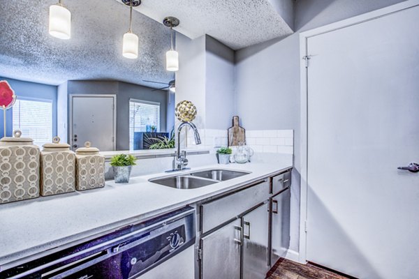 Modern kitchen featuring stainless steel appliances and granite countertops at The Oakley Apartments