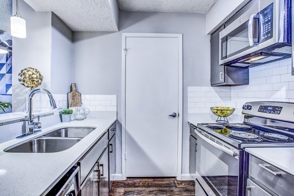 Modern kitchen with stainless steel appliances at The Oakley Apartments