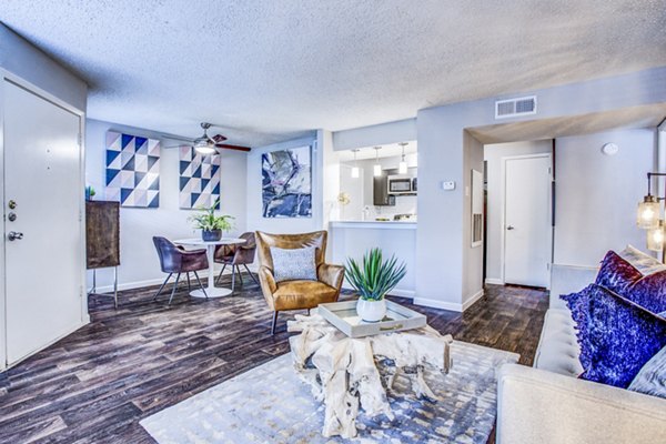 Spacious living room with modern decor and large windows at The Oakley Apartments Perfect for relaxing and entertaining guests