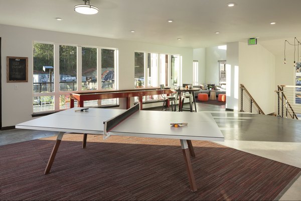 Game room with pool table and lounge seating at Spencer 68 Apartments