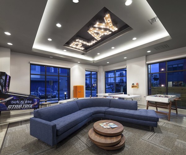 Game room with arcade machines and pool table at Spencer 68 Apartments, offering a fun and engaging recreational space for residents