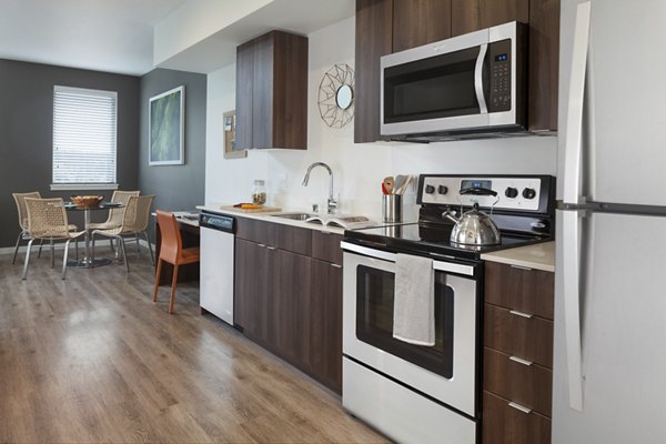 Modern kitchen with sleek cabinetry and stainless steel appliances at Spencer 68 Apartments