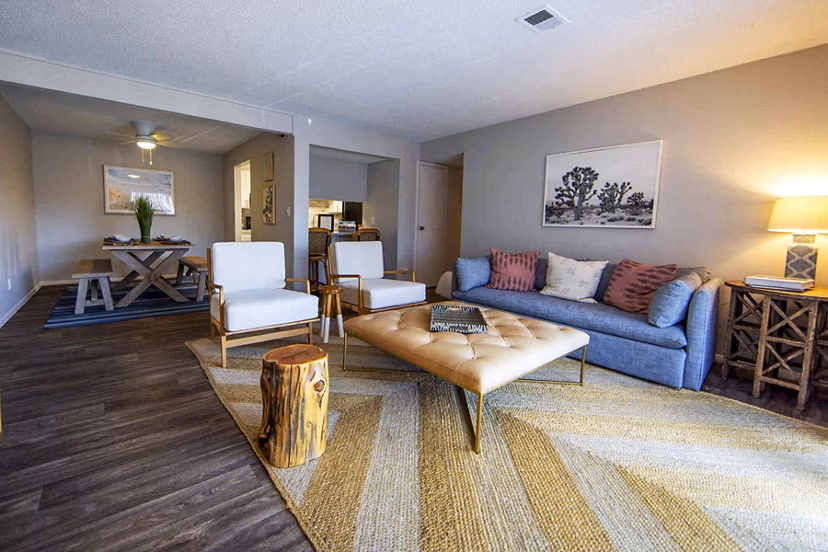 Cozy living room with modern decor and large windows in The Mica Apartments