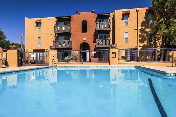 Modern pool area with sun loungers at The Mica Apartments, offering relaxation and luxury living