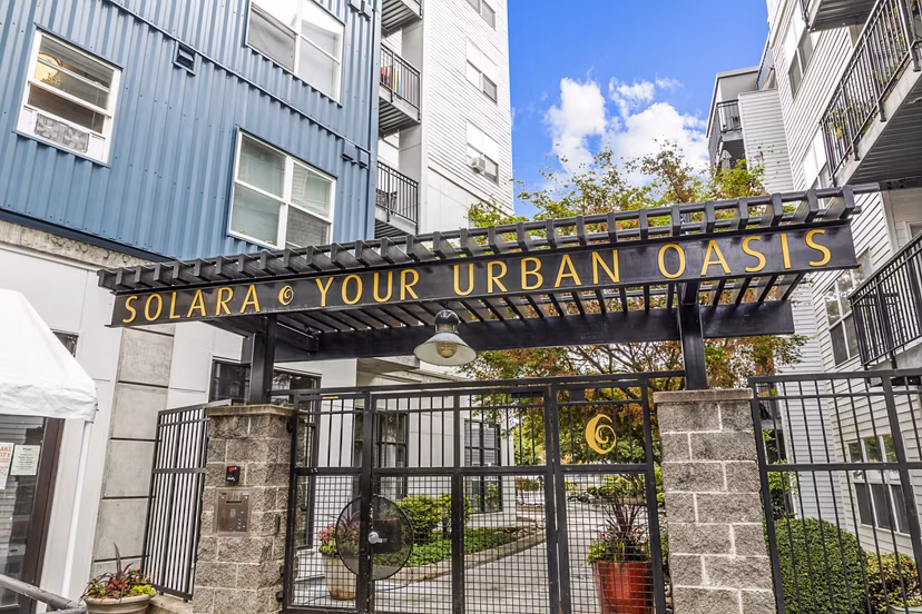 Elegant entrance at Solara Apartments with modern architecture and landscaped gardens