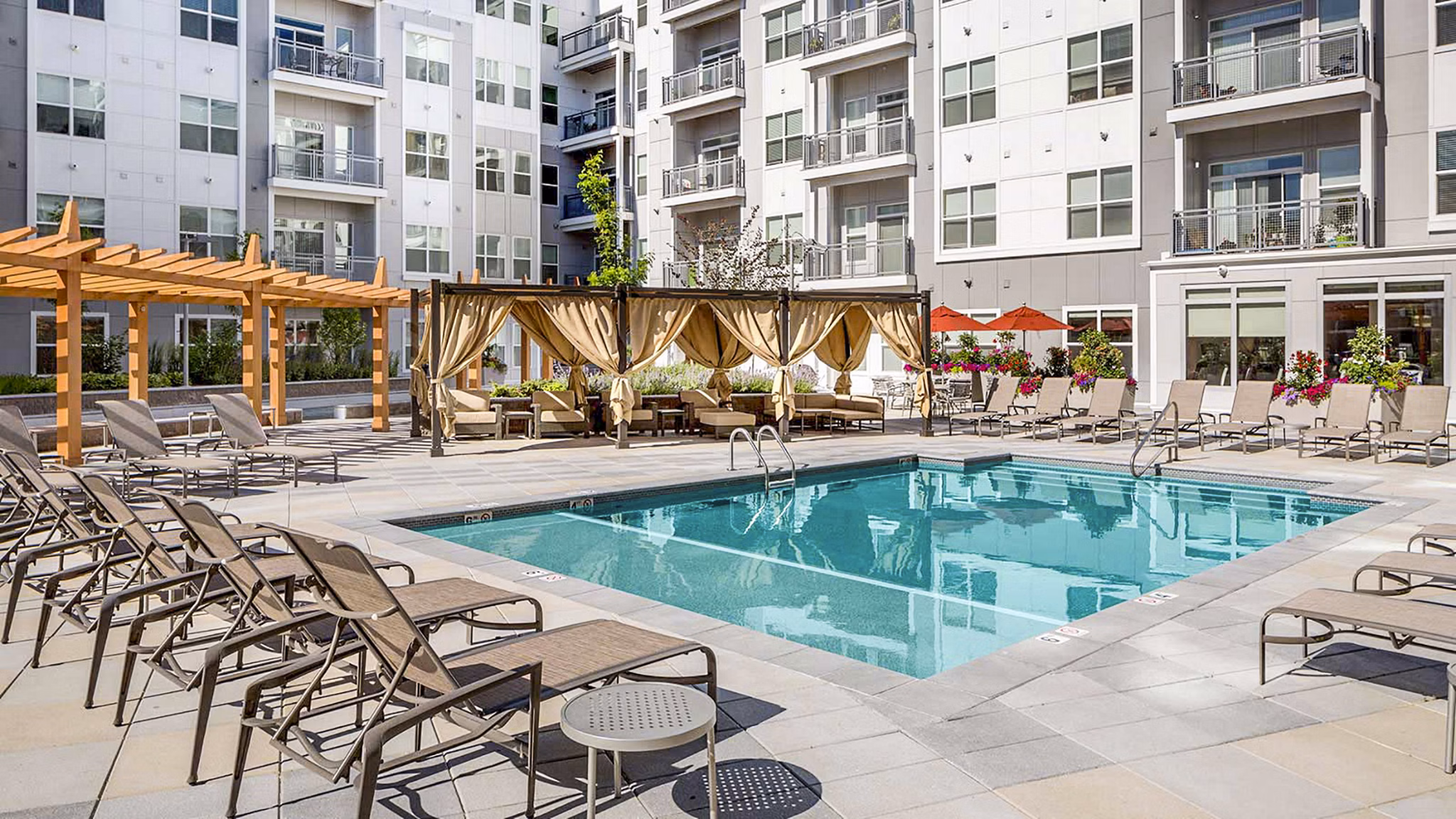 Infinity pool with sun loungers at Atmark Apartments