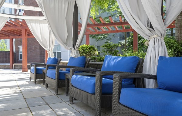 Resort-style outdoor pool at Atmark Apartments with lounge seating and greenery