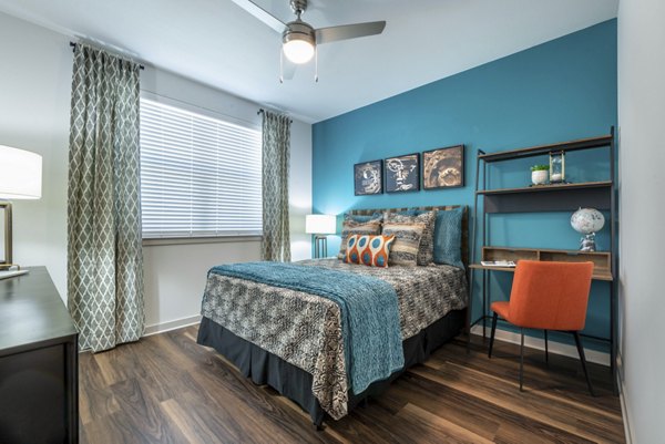 Elegant bedroom with modern decor and large windows at Prose Magnolia Apartments