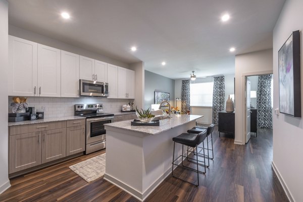 Modern kitchen with stainless steel appliances and granite countertops in Prose Magnolia Apartments, offering luxury living