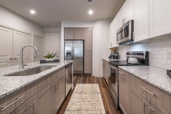 Modern kitchen equipped with stainless steel appliances at Prose Magnolia Apartments
